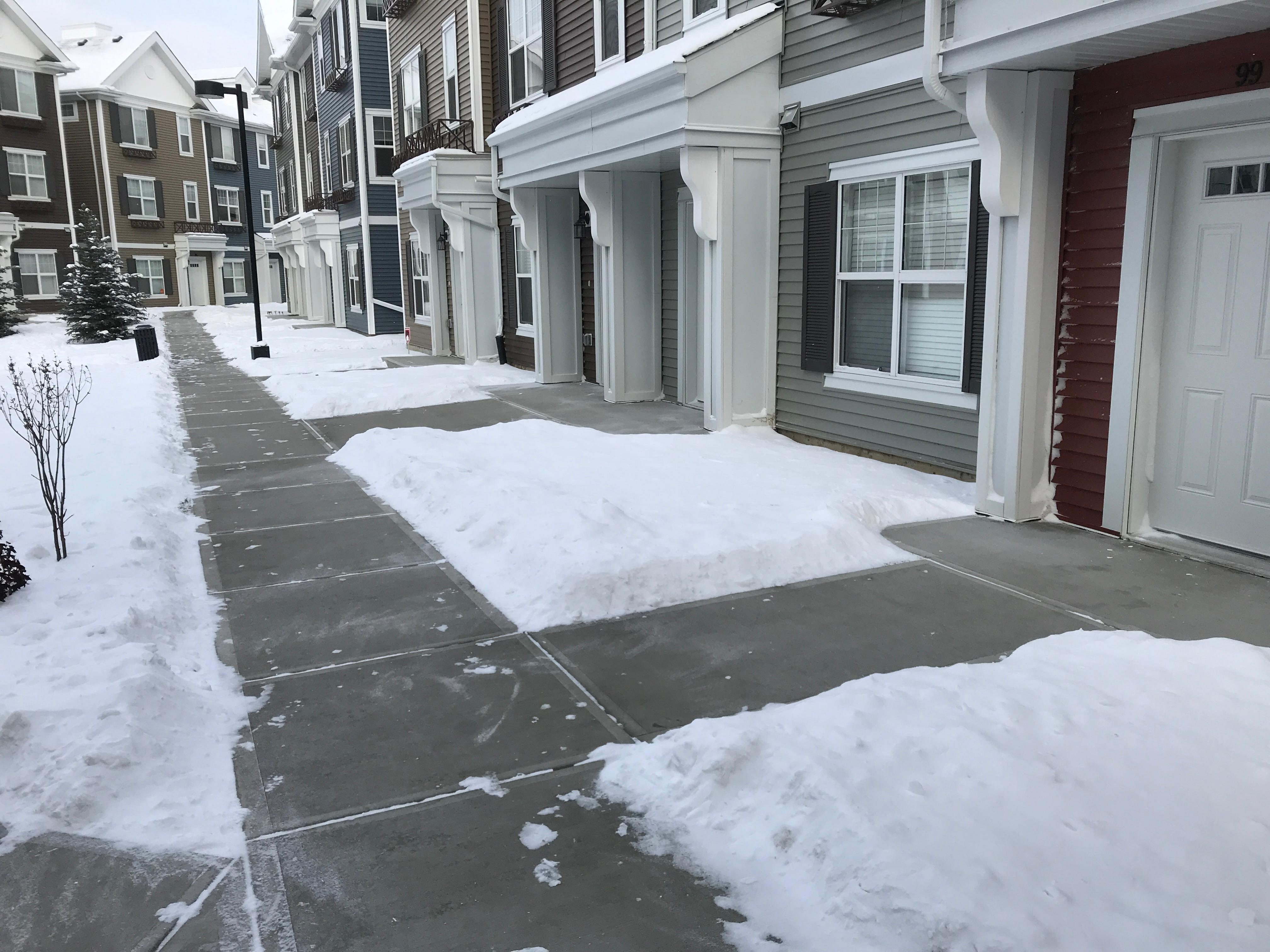Row townhouse front walkways cleared with remaining snow banks